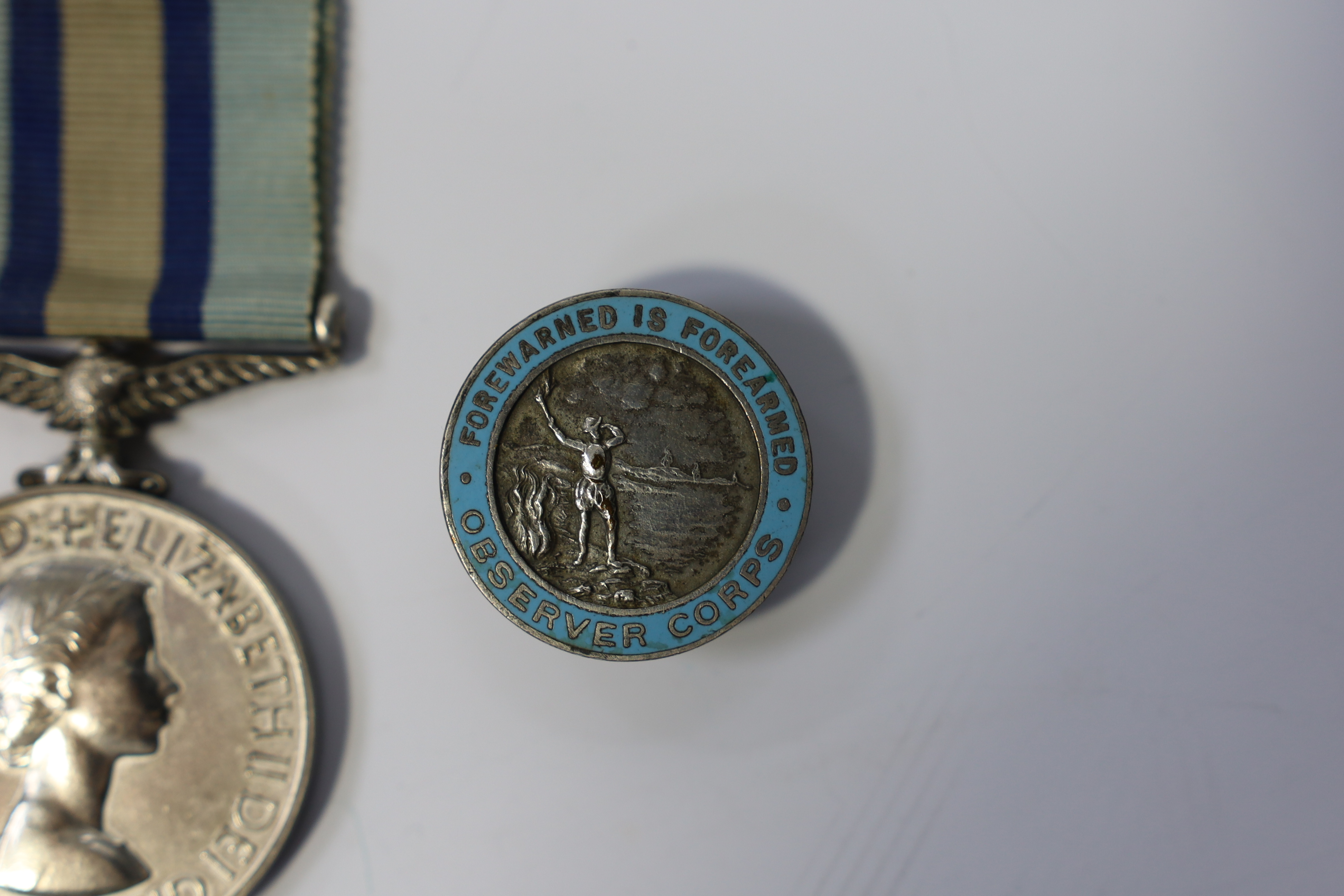 An ERII (B) Royal Observer Corps medal to Observer W.Cook with a lapel badge. Condition - fair.